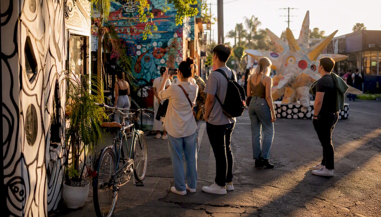 Tourists exploring colorful LA alley with murals