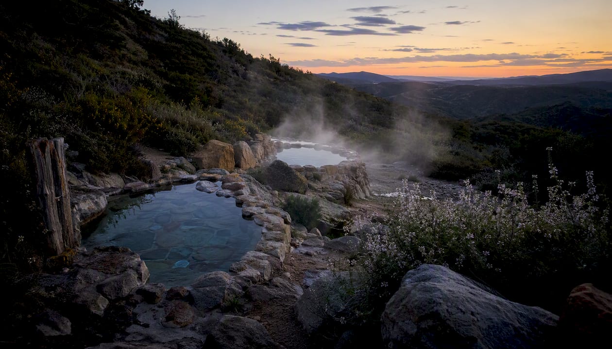Natural hot springs pool with steam in morning