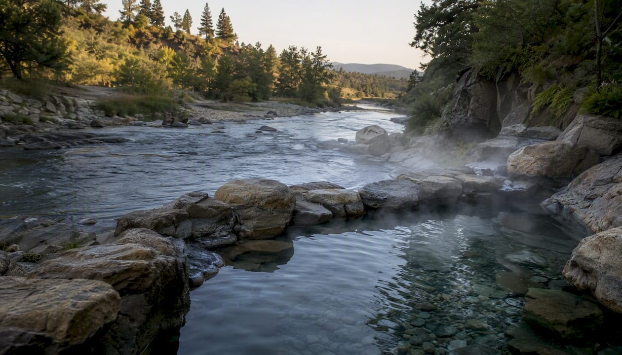 Rock-lined hot spring pools at river's edge