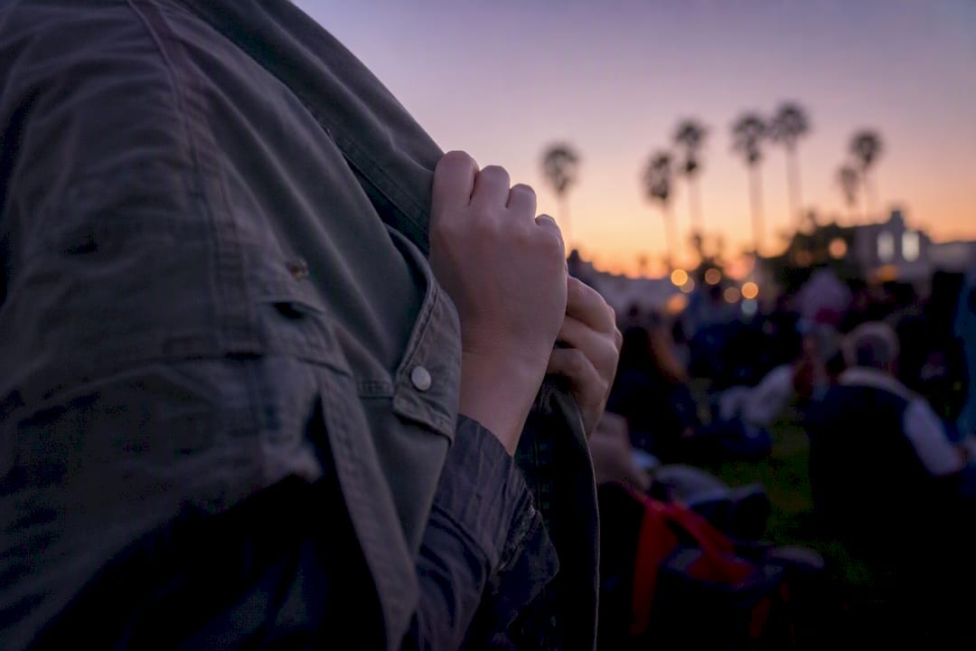 Person layering with jacket at outdoor summer concert