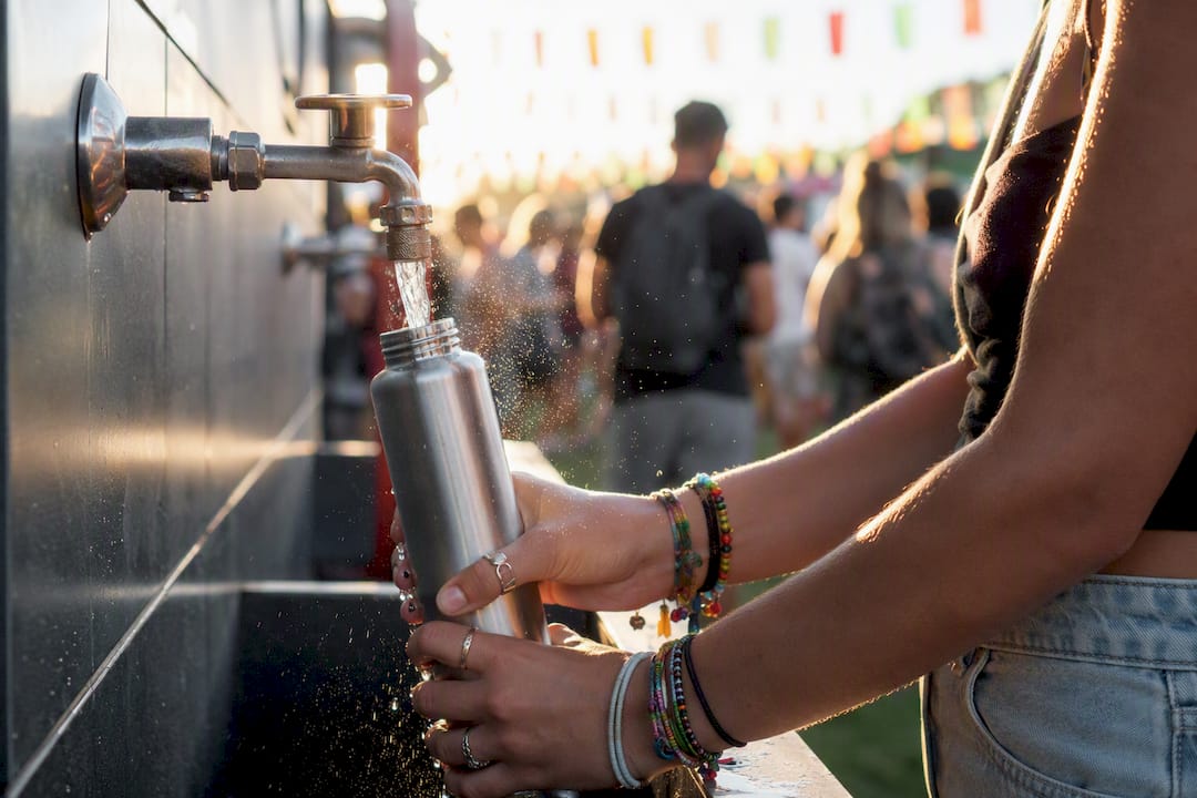 Filling refillable water bottle at concert water station