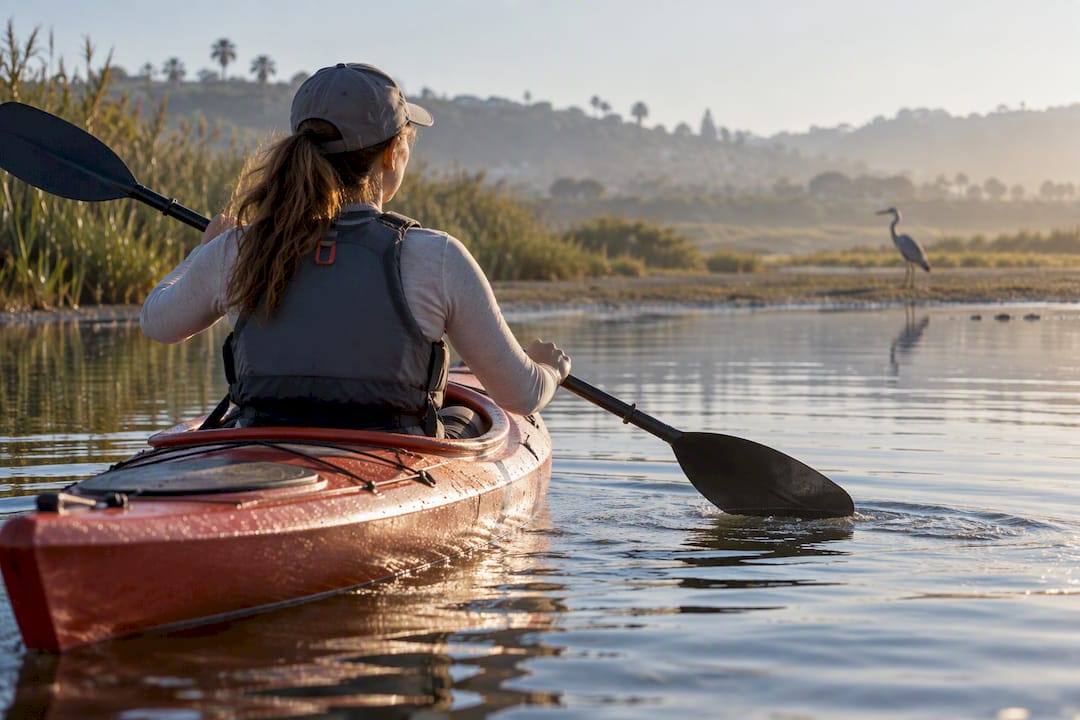 Kayaker paddling through Newport Bay estuary