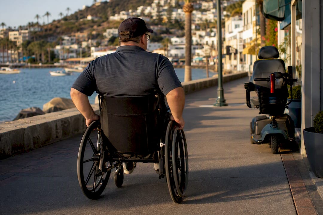 Wheelchair user on Avalon paved harbor promenade